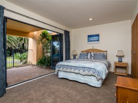 A bedroom with a bed and nightstands at La Belle Retreat - Ruakaka Holiday Apartment Ruakaka
