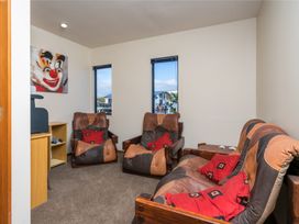 A living room with armchairs and a table at La Belle Retreat - Ruakaka Holiday Apartment in Ruakaka