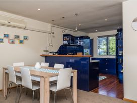 A kitchen with a dining table and chairs at La Belle Retreat - Ruakaka Holiday Apartment Ruakaka