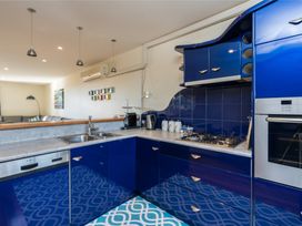 A kitchen with blue cabinets and appliances at La Belle Retreat - Ruakaka Holiday Apartment Ruakaka