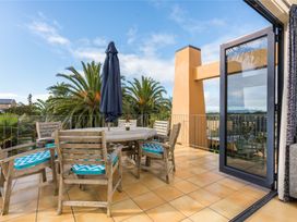 An outdoor patio with a table and chairs at La Belle Retreat - Ruakaka Holiday Apartment Ruakaka