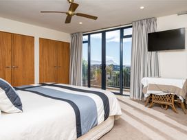 A bedroom with a bed and sliding doors at La Belle Retreat - Ruakaka Holiday Apartment Ruakaka
