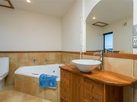 A bathroom with a bathtub, sink and toilet at La Belle Retreat - Ruakaka Holiday Apartment Ruakaka