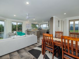 A living room with a sofa and dining table at Bay Heights Bach - Bay Of Islands Retreat Kaitaia