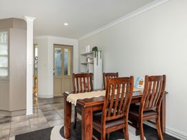 A dining room with a table and chairs at Bay Heights Bach - Bay Of Islands Retreat, Kaitaia