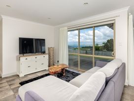A living room with a television and sofa at Bay Heights Bach - Bay Of Islands Retreat Kaitaia