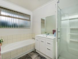 A bathroom with a bathtub, shower, and vanity unit at Bay Heights Bach - Bay Of Islands Retreat in Kaitaia