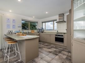 A kitchen with countertop and bar stools at Bay Heights Bach - Bay Of Islands Retreat Kaitaia