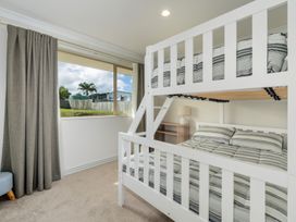 A bedroom with a bunk bed and a lamp at Bay Heights Bach - Bay Of Islands Retreat in Kaitaia