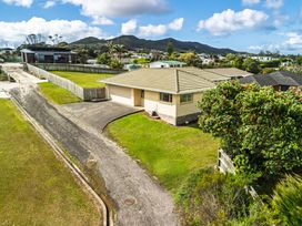 A house with a road and grass area at Bay Heights Bach - Bay Of Islands Retreat, Kaitaia
