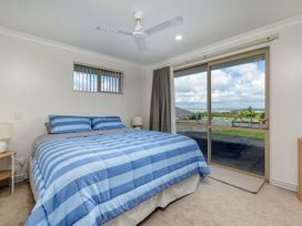 A bedroom with a bed and a window at Bay Heights Bach - Bay Of Islands Retreat, Kaitaia