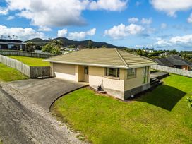 A house with a garage and driveway at Bay Heights Bach - Bay Of Islands Retreat Kaitaia