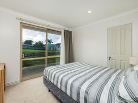 A bedroom with a bed and a window at Bay Heights Bach - Bay Of Islands Retreat Kaitaia
