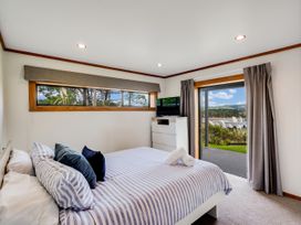 A bedroom with a bed and dresser at Raglan Holiday Home in Raglan