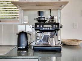 A kitchen with a coffee machine and kettle at Raglan Holiday Home in Raglan