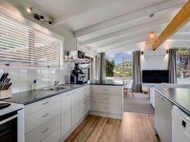 A kitchen with a coffee machine and a view at Raglan Holiday Home in Raglan