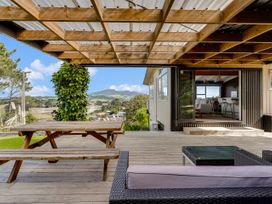An outdoor area with a table and seating at Raglan Holiday Home in Raglan