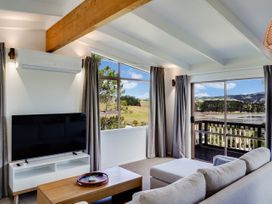 A living room with a television and sofa at Raglan Holiday Home in Raglan