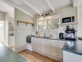 A kitchen with appliances and countertop at Raglan Holiday Home in Raglan