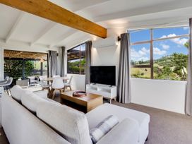 A living room with a sofa and television at Raglan Holiday Home in Raglan