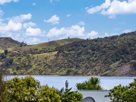 A view of hills and water at Raglan Holiday Home in Raglan