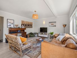 A living room with a sofa and television at Raglan Holiday Home in Raglan
