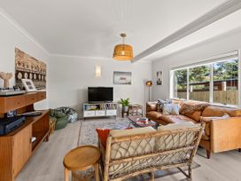 A living room with a sofa and television at Raglan Holiday Home in Raglan