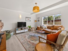 A living room with a sofa and television at Raglan Holiday Home in Raglan