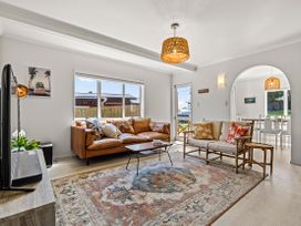 A living room with a sofa and armchair at Raglan Holiday Home in Raglan