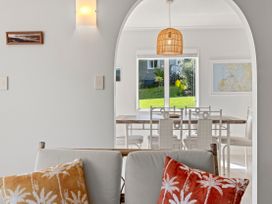 A dining room with a wooden table and chairs at Raglan Holiday Home in Raglan
