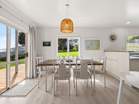 A dining room with a table and chairs at Raglan Holiday Home in Raglan
