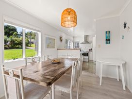 A dining room with a table and chairs at Raglan Holiday Home in Raglan