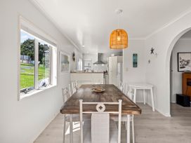 A dining room with a table and chairs at Raglan Holiday Home in Raglan