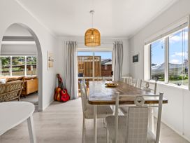 A dining room with a table and chairs at Raglan Holiday Home in Raglan