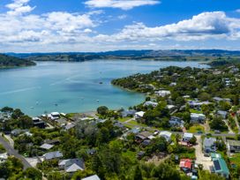 A view of houses and boats near water at Raglan Holiday Home in Raglan