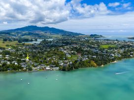 Aerial view of houses and water at Raglan Holiday Home in Raglan