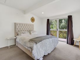 A bedroom with a bed and side table at Sundowners - Mangawhai Heads Holiday Home, Mangawhai