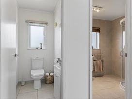 A bathroom with a toilet and a shower at Sundowners - Mangawhai Heads Holiday Home in Mangawhai