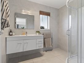 A bathroom with a vanity and mirror at Sundowners - Mangawhai Heads Holiday Home, Mangawhai