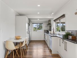 A kitchen with a table and chairs at Sundowners - Mangawhai Heads Holiday Home Mangawhai