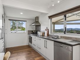 A kitchen featuring a sink, stove, and cabinets at Sundowners - Mangawhai Heads Holiday Home, Mangawhai