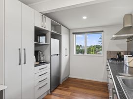 A kitchen with a refrigerator, stove, and sink at Sundowners - Mangawhai Heads Holiday Home in Mangawhai