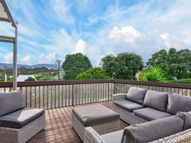 A seating area with outdoor furniture at Sundowners - Mangawhai Heads Holiday Home in Mangawhai