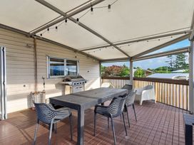 A deck with a table and chairs at Sundowners - Mangawhai Heads Holiday Home in Mangawhai