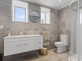 A bathroom with a sink and shower at Sundowners - Mangawhai Heads Holiday Home in Mangawhai
