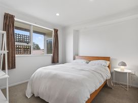 A bedroom with a bed and window at Sundowners - Mangawhai Heads Holiday Home, Mangawhai