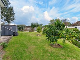 A garden with grass and fruit trees at Sundowners - Mangawhai Heads Holiday Home, Mangawhai