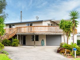A house with a balcony and garage at Sundowners - Mangawhai Heads Holiday Home Mangawhai
