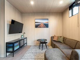 A living room with a sofa and television at Stonepeak - Queenstown Holiday Home in Queenstown