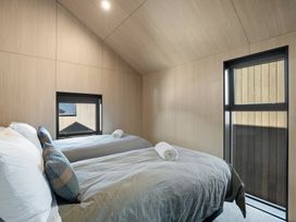 A bedroom with two beds and windows at Stonepeak - Queenstown Holiday Home in Queenstown